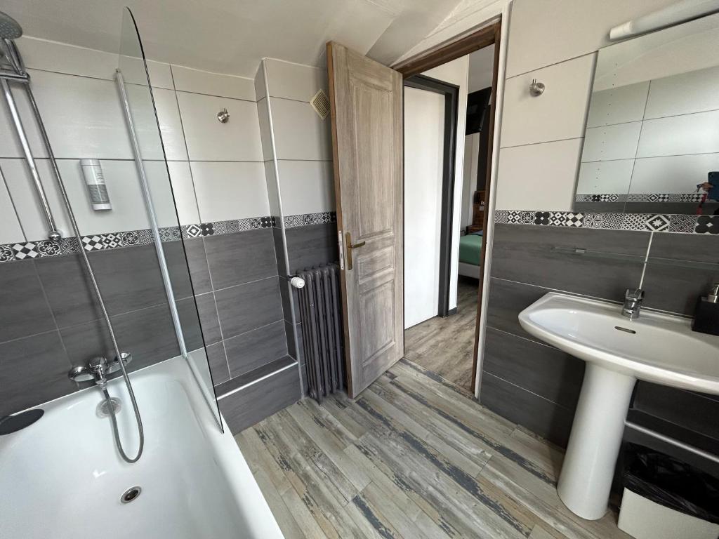 a bathroom with a tub and a sink and a shower at Le Richelieu Bacchus in Fontainebleau