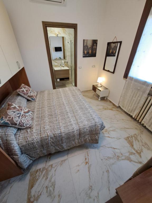 a bedroom with a bed and a marble floor at Le Terrazze in Ferrara