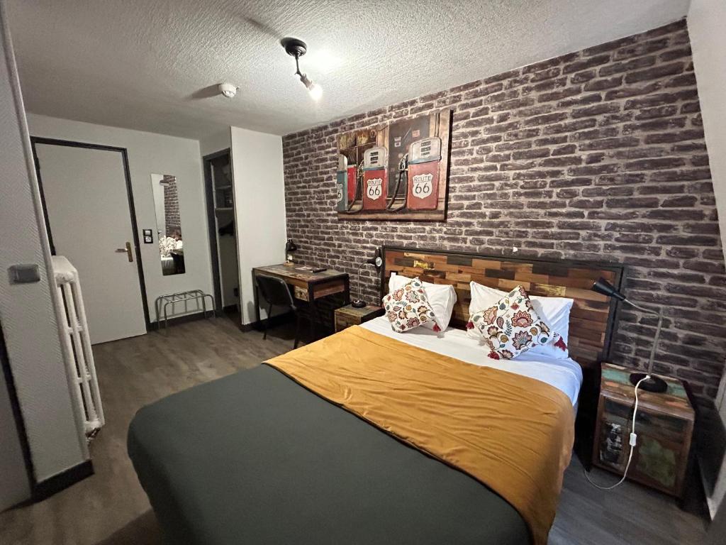 a bedroom with a brick wall and a bed at Le Richelieu Bacchus in Fontainebleau