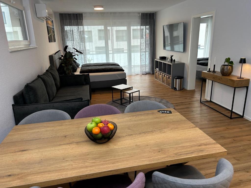 un soggiorno con tavolo in legno e cesto di frutta; di Jill Apartments a Rust