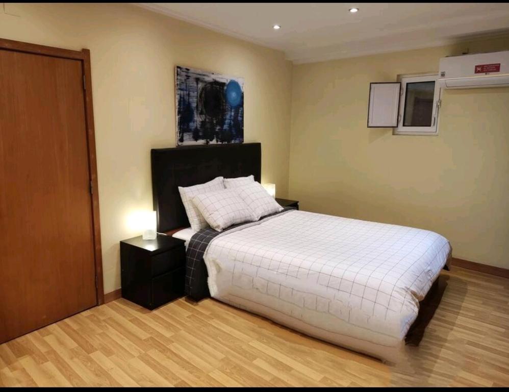 a bedroom with a large white bed with a night stand at Apartamento acolhedor no coração de Lisboa in Lisbon