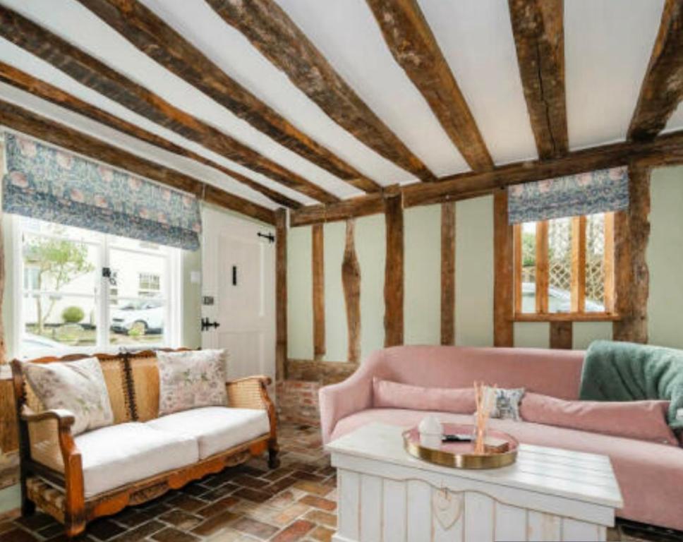 a living room with a couch and a table at Little Mouse Cottage in Lavenham