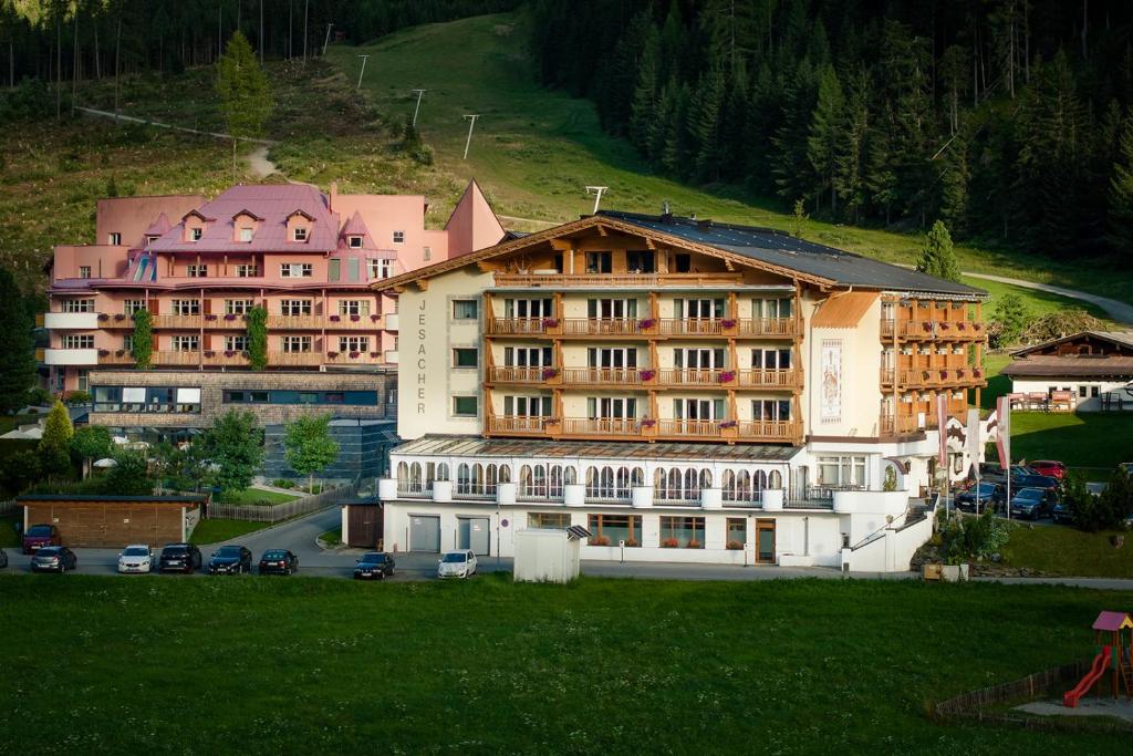 a group of buildings with cars parked in a field at Hotel Jesacherhof 4s in Sankt Jakob in Defereggen