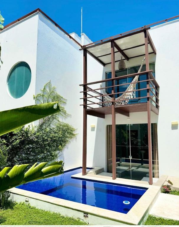 a house with a swimming pool and a balcony at La Reserve Villa Tropicana in Pipa