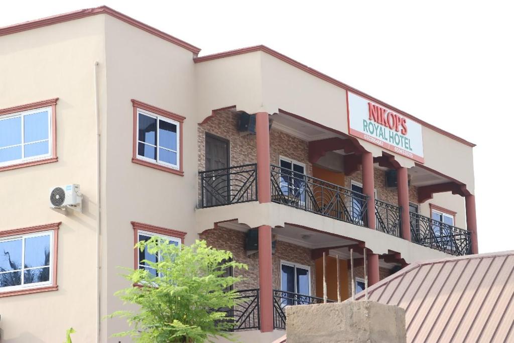 - un grand bâtiment blanc avec un panneau dans l'établissement NIKOPS ROYAL HOTEL, à Accra
