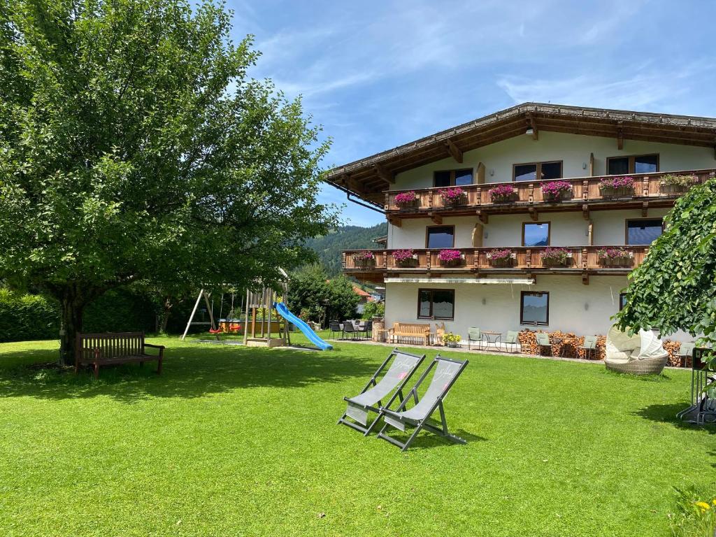 due sedie nel cortile di una casa con parco giochi di Hotel Acherl ad Achenkirch