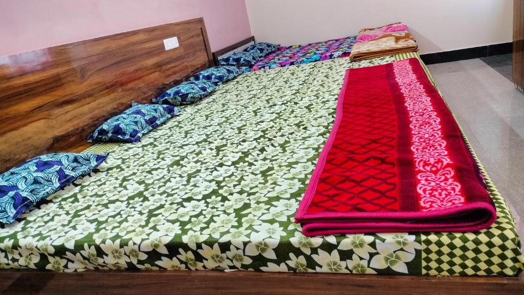a bed with a colorful comforter on it at Milan Palace Deoghar in Deoghar