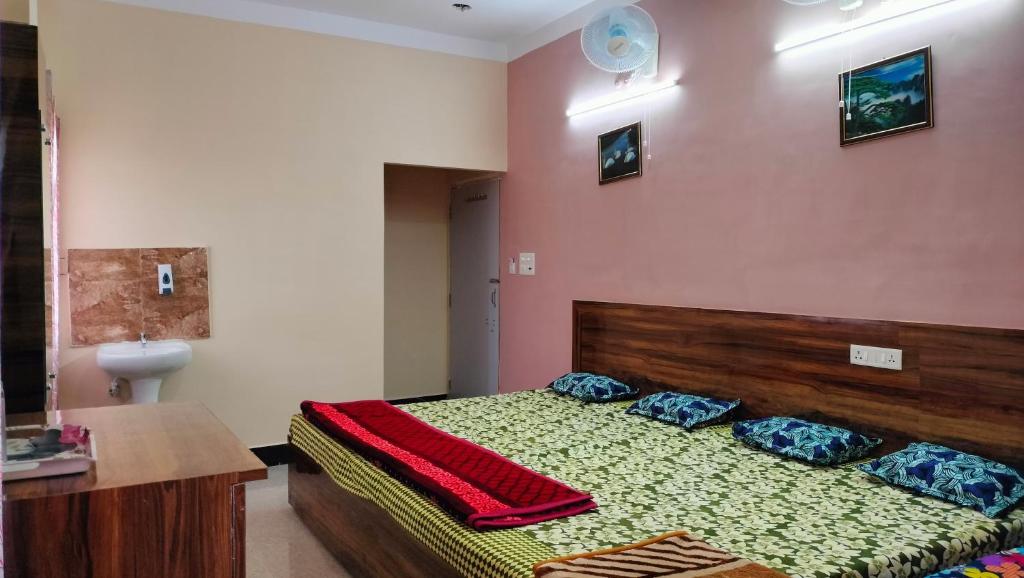 a bedroom with a bed with a wooden headboard and pillows at Milan Palace Deoghar in Deoghar