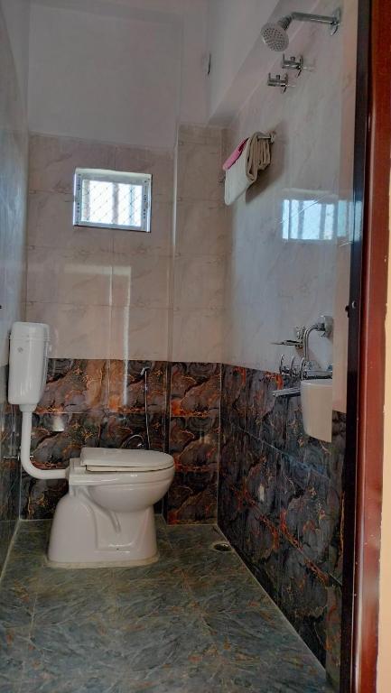 a bathroom with a toilet and a sink at Milan Palace Deoghar in Deoghar