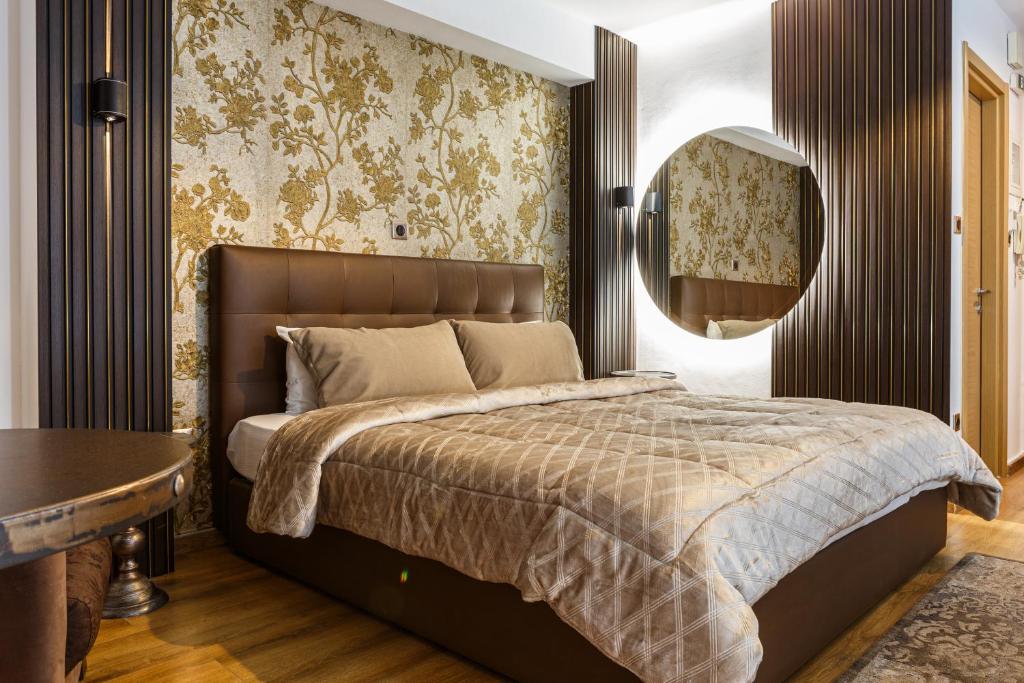 a bedroom with a large bed and a mirror at Limani Comfort Rooms in Thessaloniki