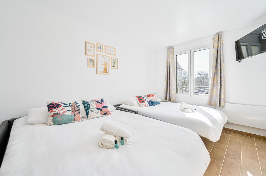 zwei Betten in einem Zimmer mit Fenster in der Unterkunft Le CozyBussy - 4 pers - Disney & Paris - Parking in Bussy-Saint-Georges