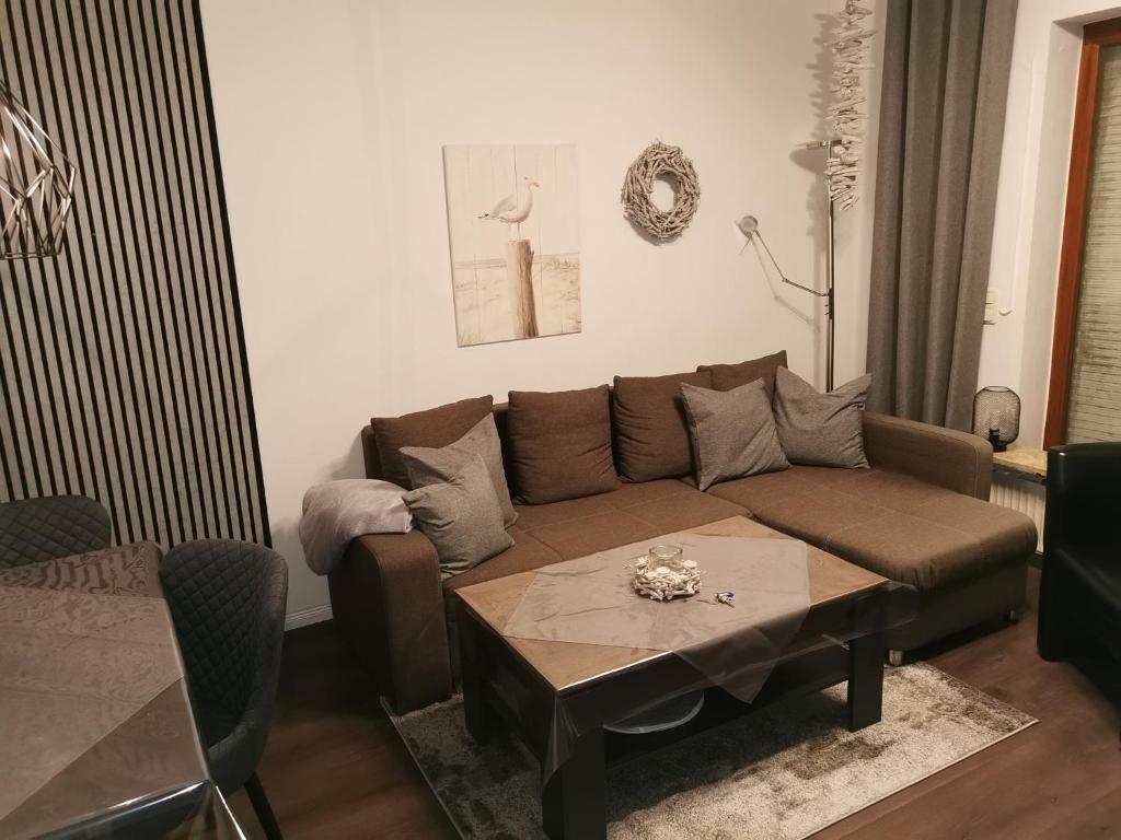 uma sala de estar com um sofá castanho e uma mesa em Ferienwohnung Steffens - "Wicheldorfstraße" em Grömitz