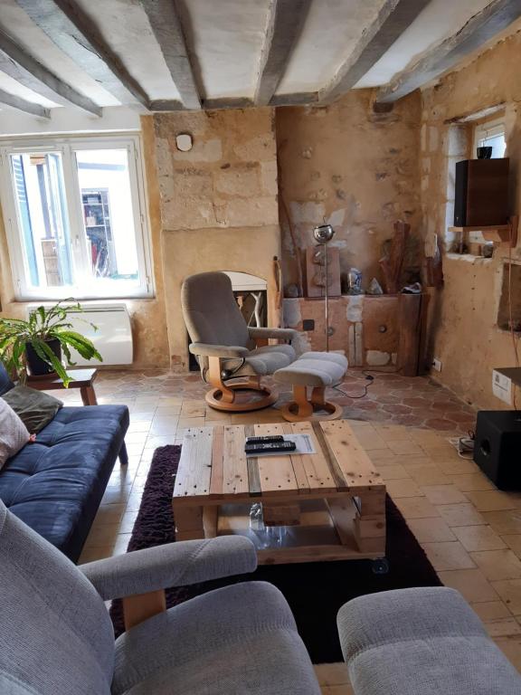 a living room with a couch and a coffee table at Le gîte des pierres in Nogent-le-Rotrou