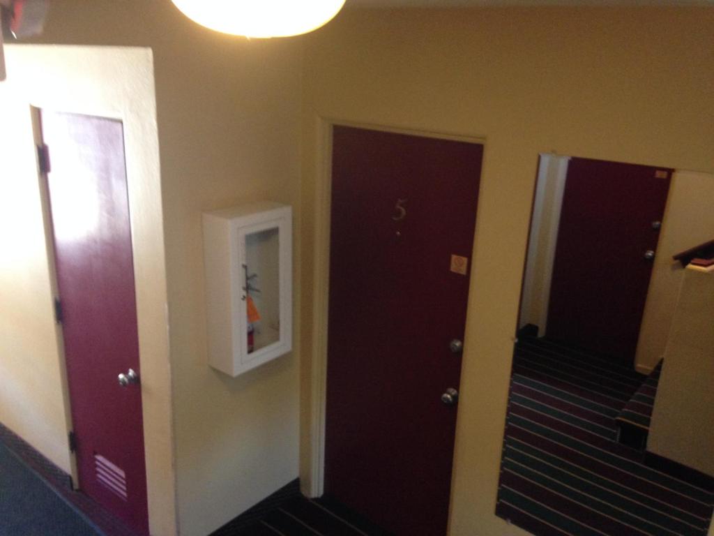 a hallway with two purple doors and a light at Rugged Country Lodge in Pendleton