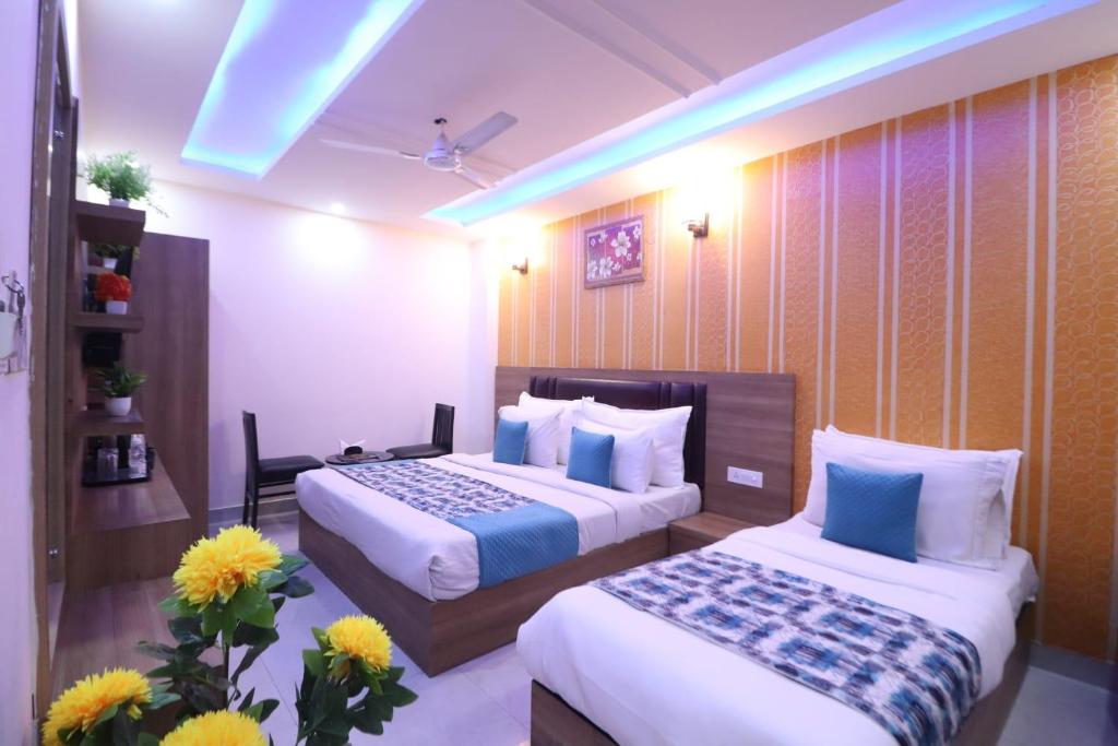 a hotel room with two beds and flowers at Hotel Grand TuCasa Near International Airport in New Delhi