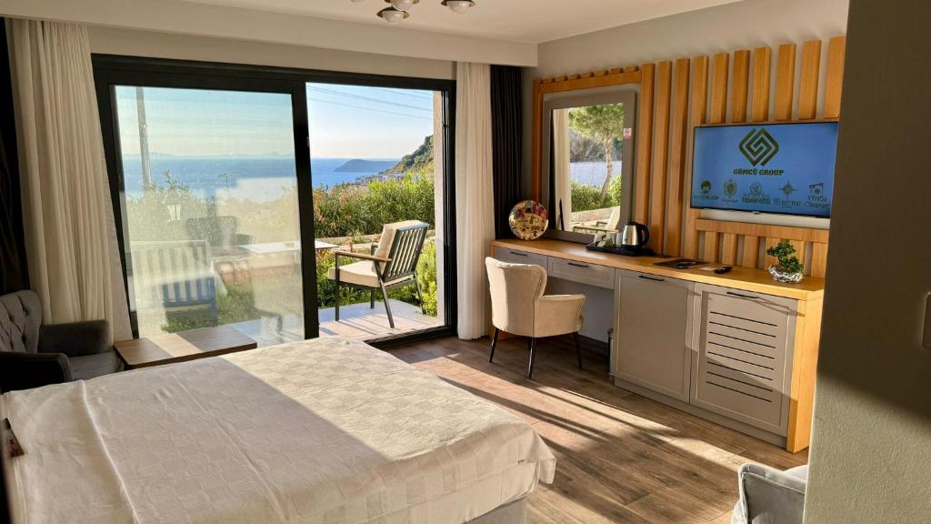 a bedroom with a bed and a desk with a television at The Rest Port Argento in Bodrum City