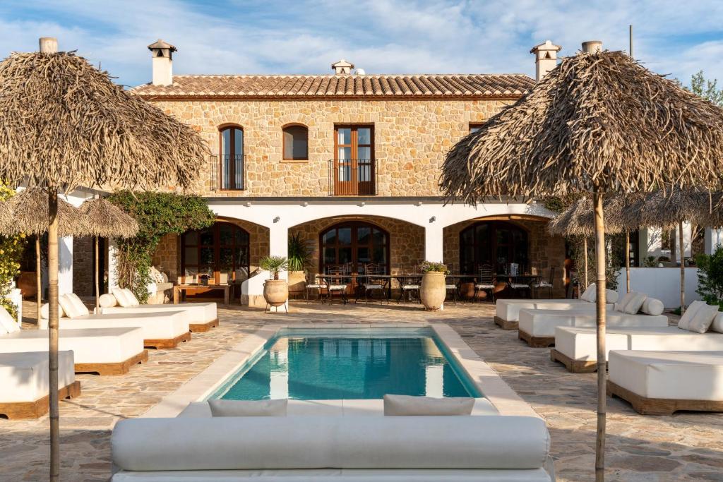 a resort with a swimming pool and chairs and umbrellas at Cuatre Finques in Jalón