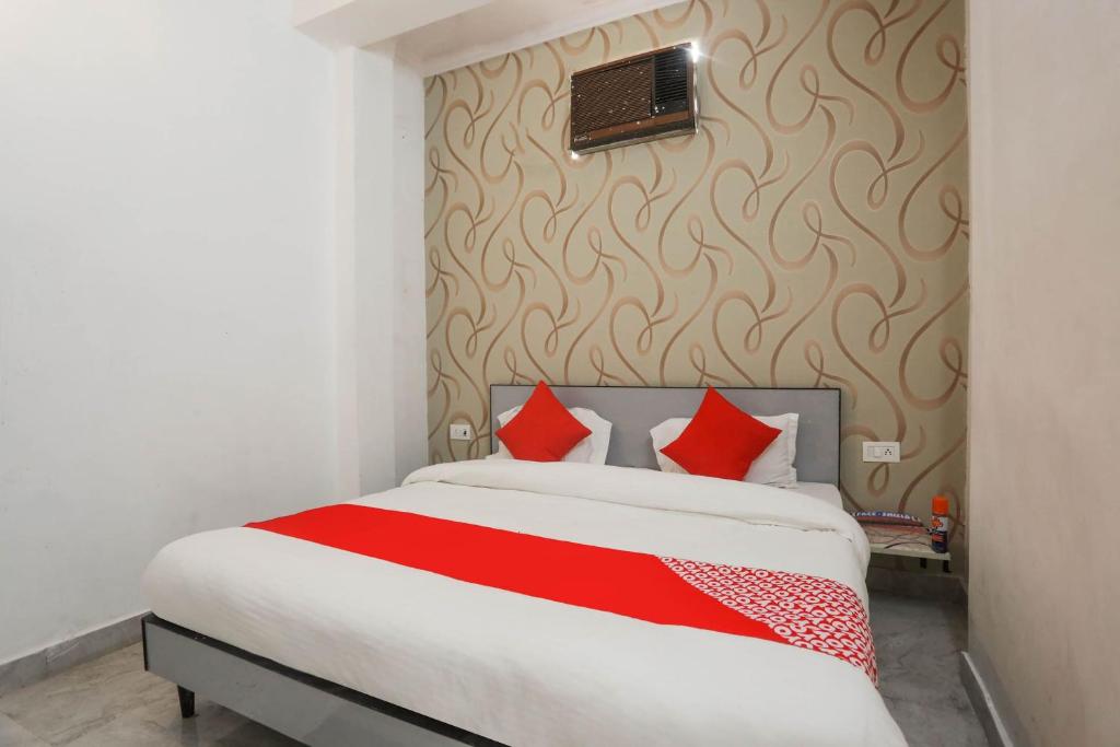 1 dormitorio con 1 cama grande con almohadas rojas en Super OYO Dream Town, en Nueva Delhi