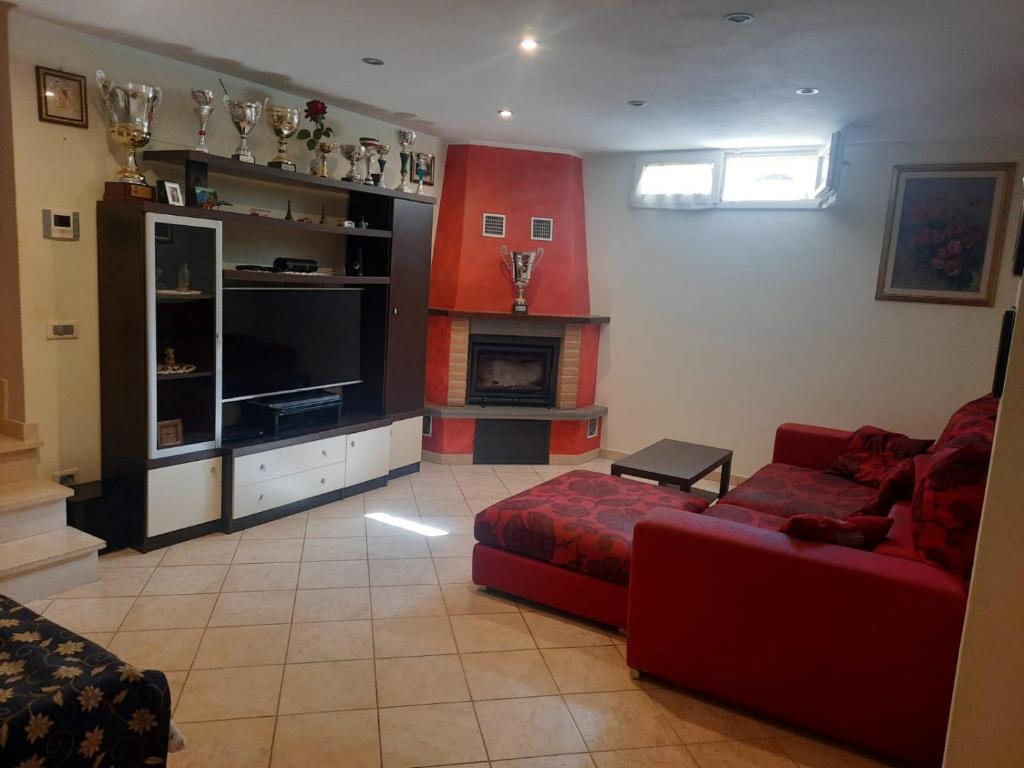 - un salon avec un canapé rouge et une cheminée dans l'établissement Villa Anna, à Massarosa