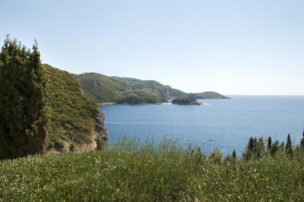 une vue d'une grande étendue d'eau avec une colline dans l'établissement Thalia's House, à Paleokastritsa