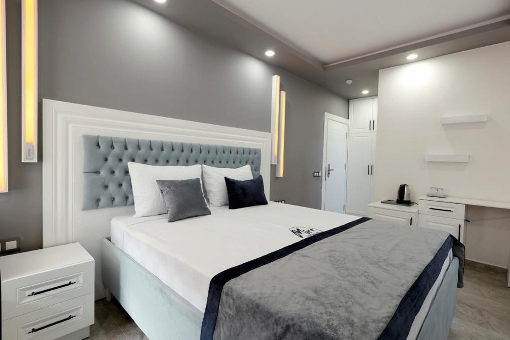 a large white bedroom with a large white bed at Mira Hotel Antalya in Antalya