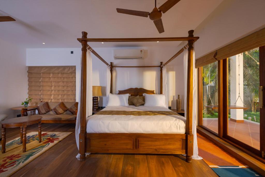 a bedroom with a canopy bed and a table at The Isle By Area 707 in Alwaye