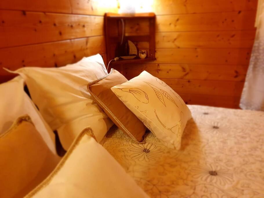 a bed with four pillows on it in a room at Chalet Chaleureux in La Plaine des Palmistes