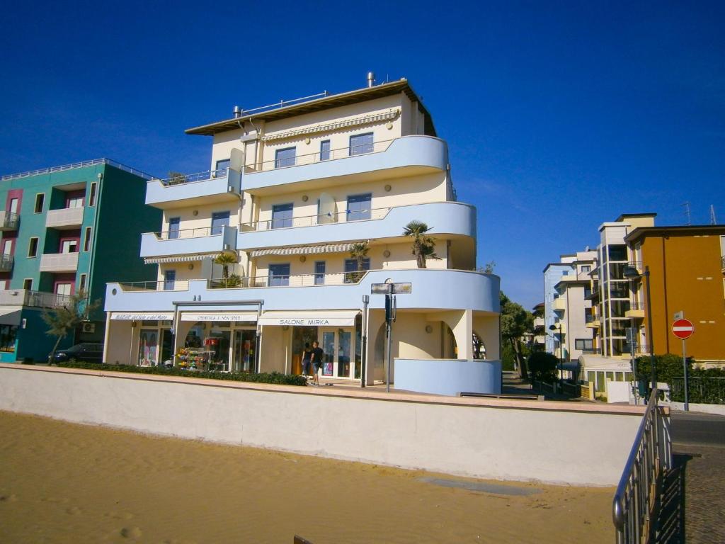 un edificio sulla spiaggia accanto ad alcuni edifici di Residence Diana Frontemare - Agenzia Cocal a Caorle