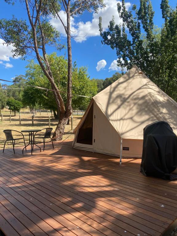 ein Zelt auf einer Terrasse mit einem Tisch und Stühlen in der Unterkunft Camp Crusty Eldorado in Eldorado