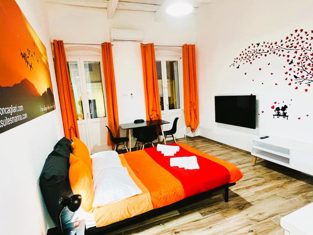 una camera con letto e TV a schermo piatto di Apart Suites Marina a Cagliari