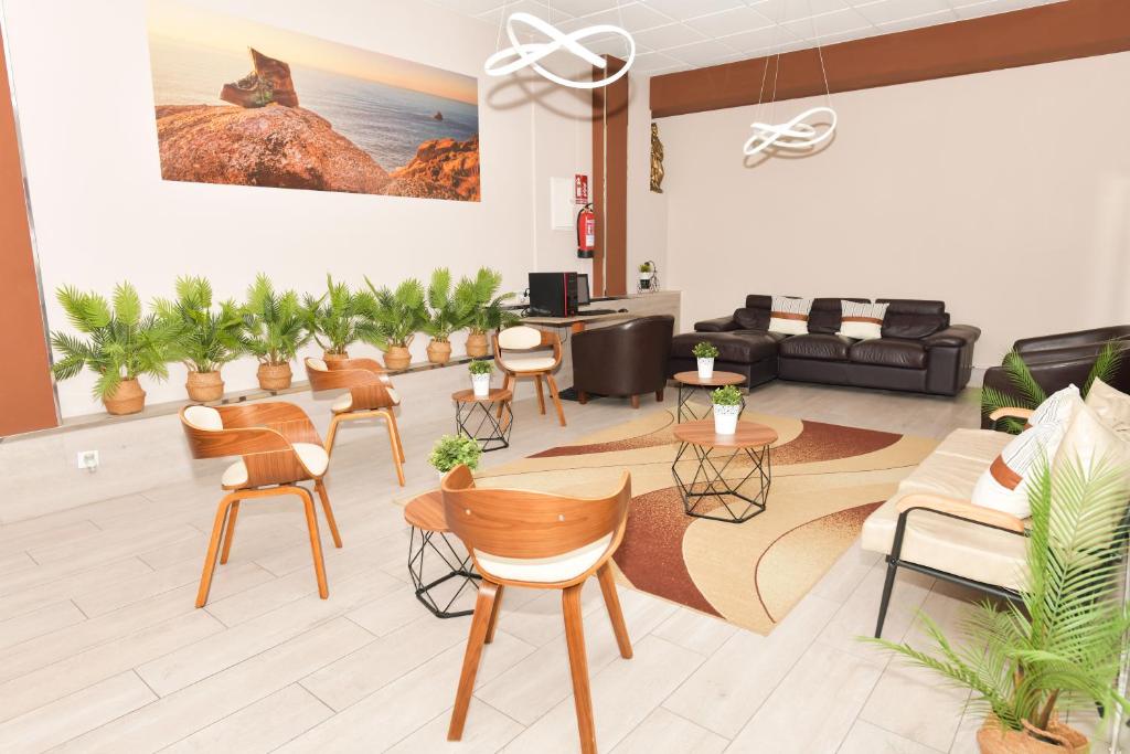ein Wohnzimmer mit Stühlen, einem Sofa und Tischen in der Unterkunft Hotel Ancora Urban Center in Kap Finisterre