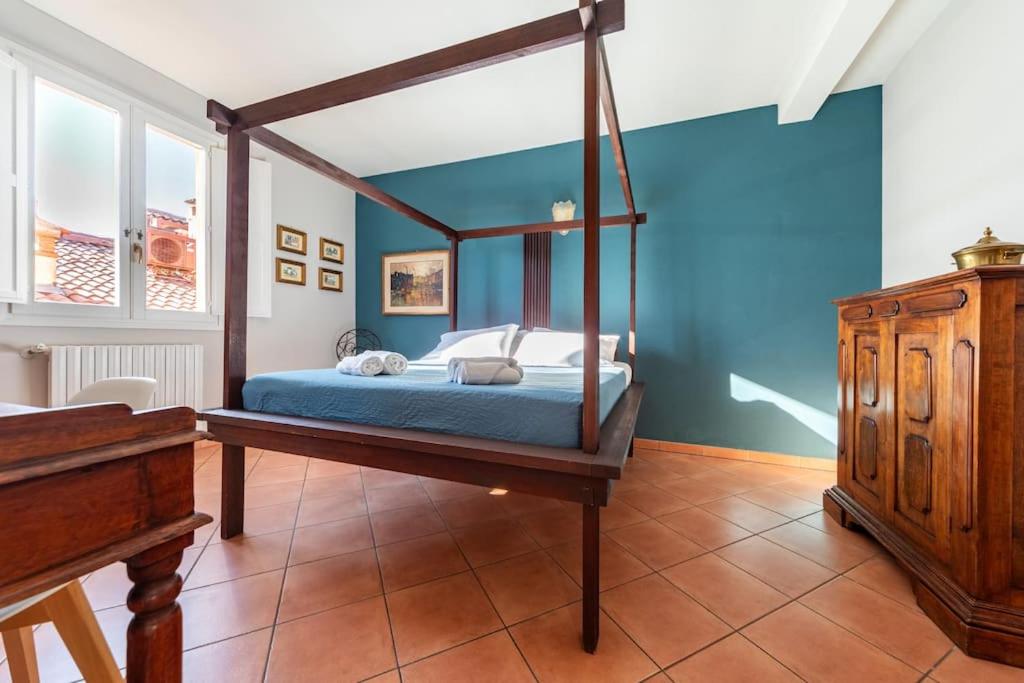 ボローニャにあるSan Giorgio Apartmentの青い壁のベッドルーム1室(天蓋付きベッド1台付)