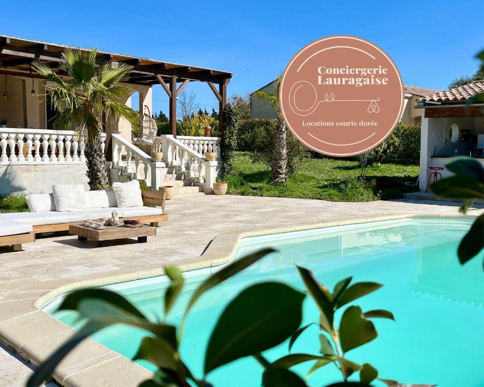 una piscina frente a una casa con un cartel en Villa les cigales - Paisible avec piscine en Mas-Saintes-Puelles