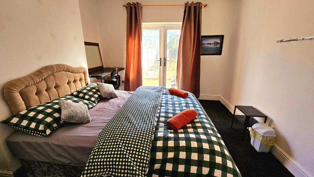 a bedroom with a bed with checkered pillows at Wolves Living in Bushbury