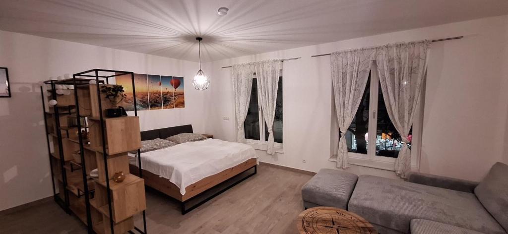 - une chambre avec un lit, un canapé et des fenêtres dans l'établissement Wohlfühlen, à Gänserndorf