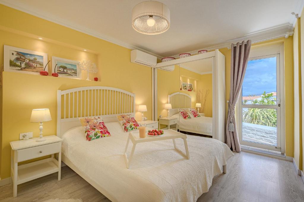 1 dormitorio con 2 camas y ventana grande en BuenaVista Romantic Bungalow in Costa Adeje en Adeje