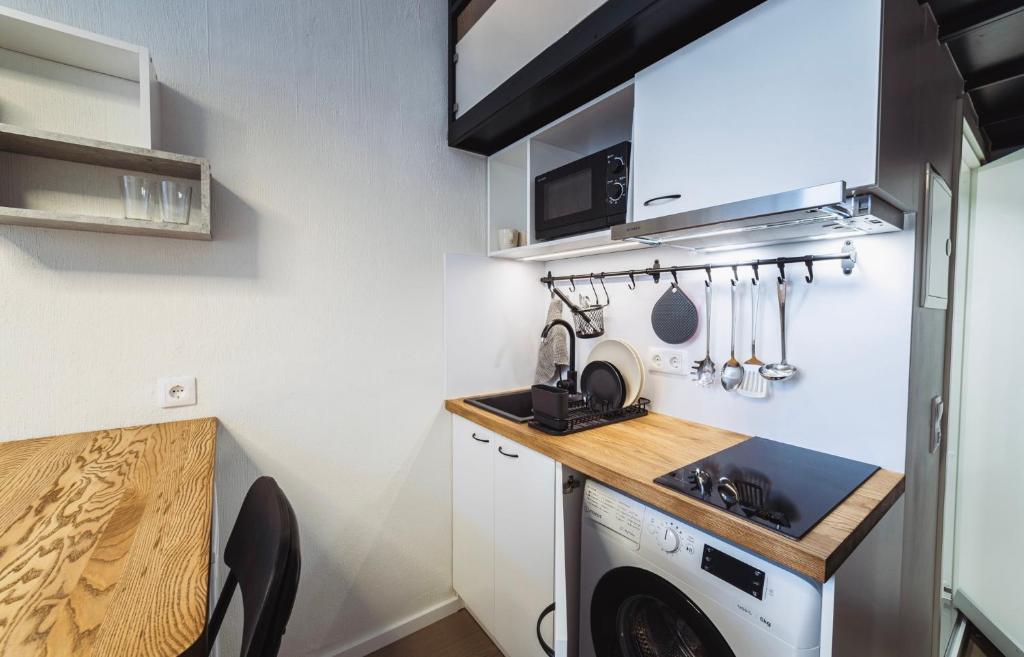 Il comprend une petite cuisine avec un évier et un lave-linge. dans l'établissement City Apartments, à Tallinn