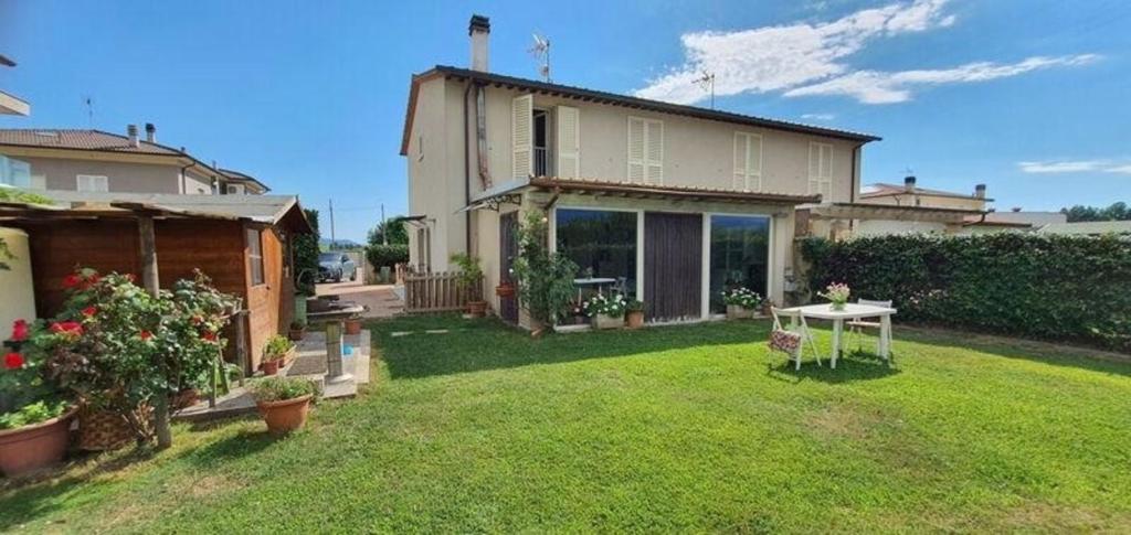 una casa con un cortile con un tavolo di Ferienhaus für 5 Personen ca 125 qm in Lucca, Toskana Provinz Lucca a Lucca