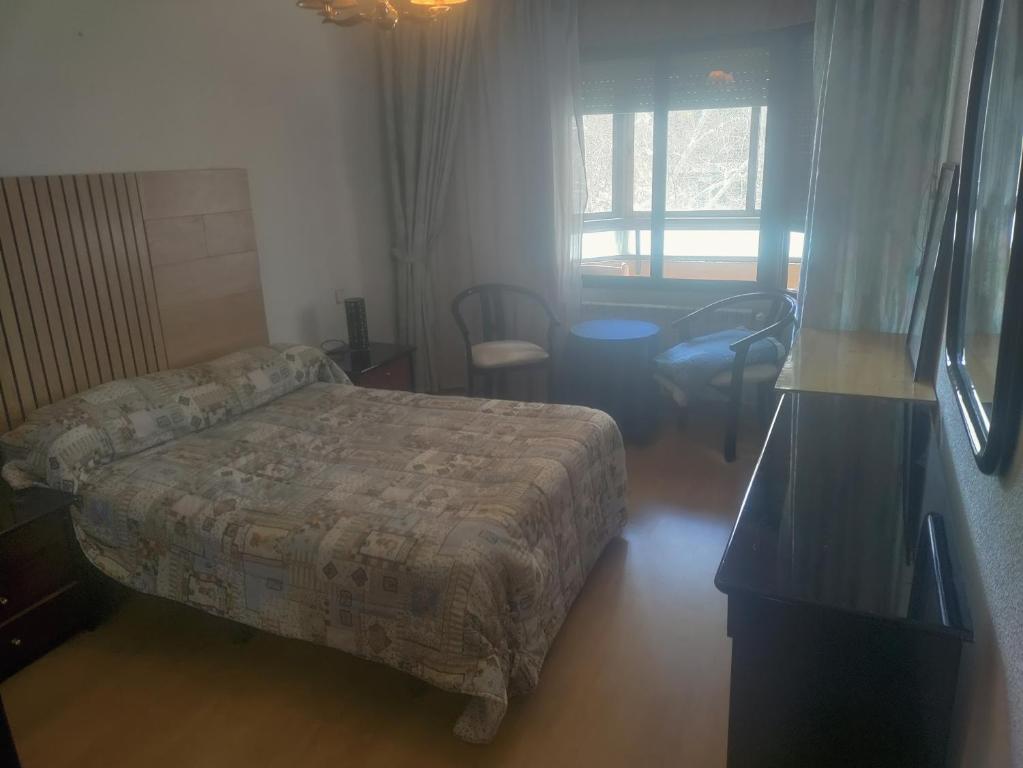 1 dormitorio con 1 cama, mesa y sillas en Piso en avenida España 49, en Albacete