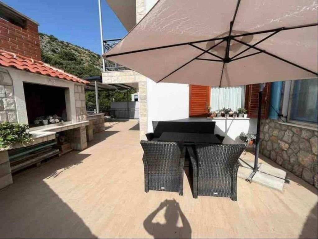 Štikovica的住宿－Appartement mit zwei Terrassen，庭院内桌椅和遮阳伞