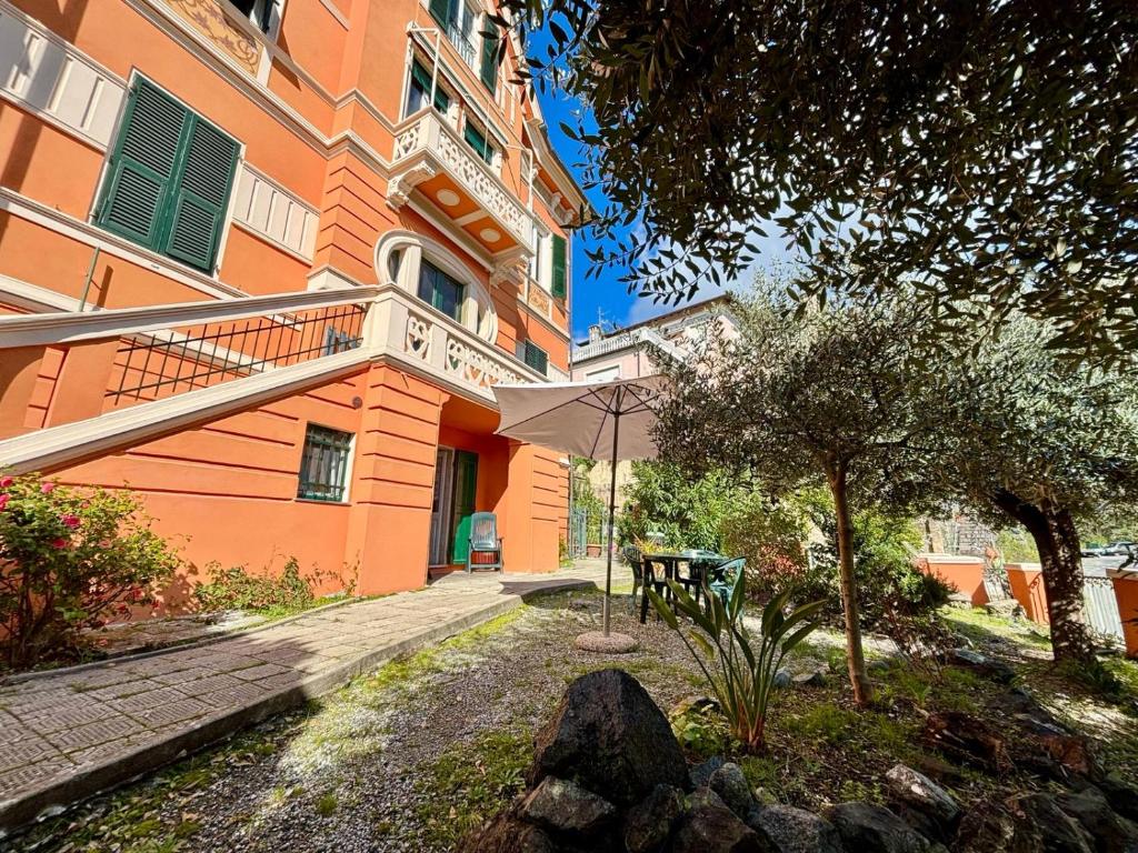un edificio con un tavolo e un albero di fronte ad esso di Il giardino degli ulivi a Levanto