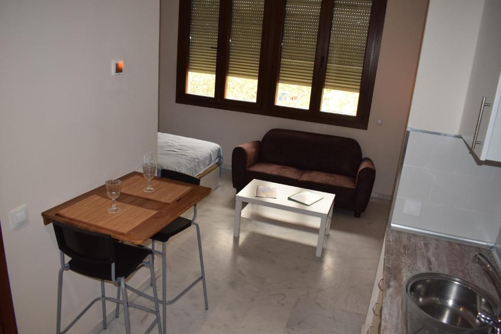 uma pequena sala de estar com uma mesa e um sofá em Estudio Fibes-Palacio em Sevilha