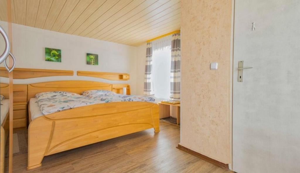 a bedroom with a wooden bed in a room at Ferienwohnungen Wald und Wasser Fam.Schurat in Feldberg