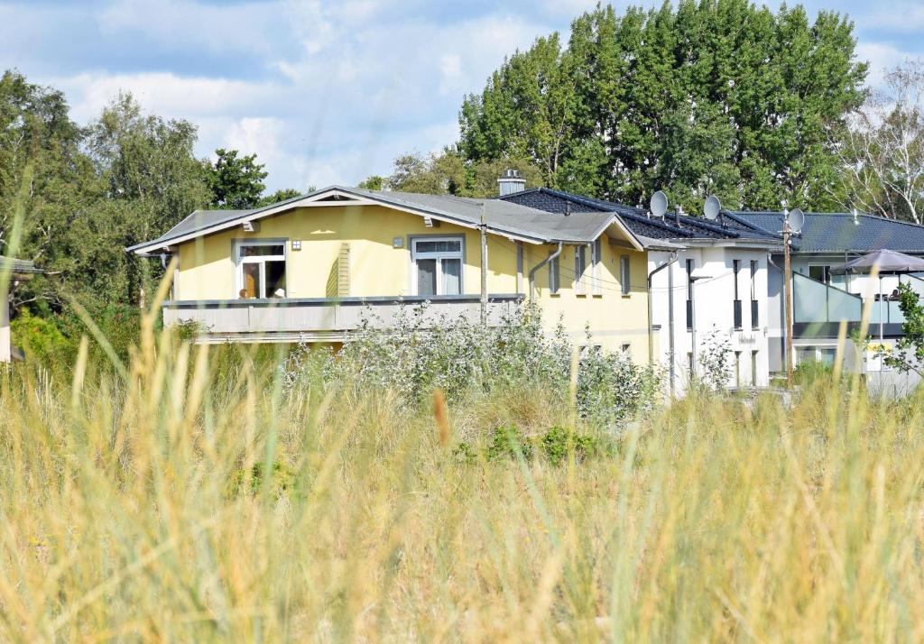 a yellow house in the middle of a field at Strandhaus Goehren in Göhren