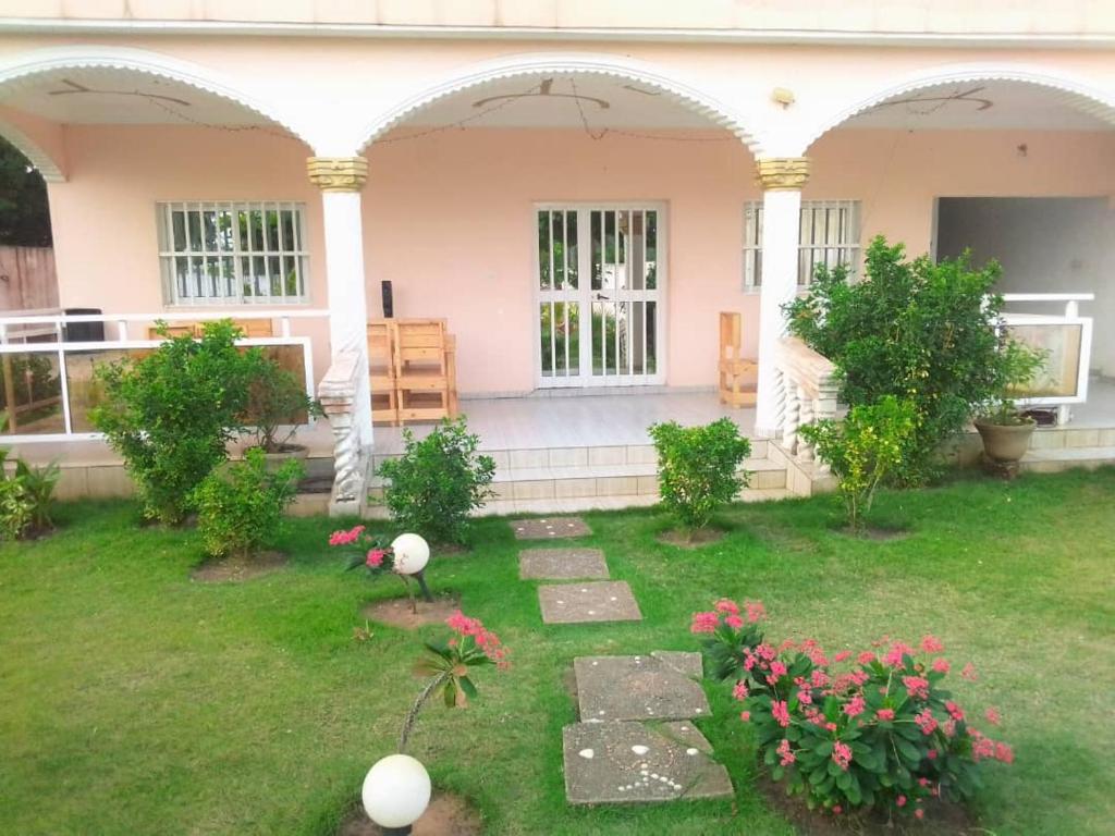 a house with two arches and a yard with flowers at Maison de détente Luxury in Aného