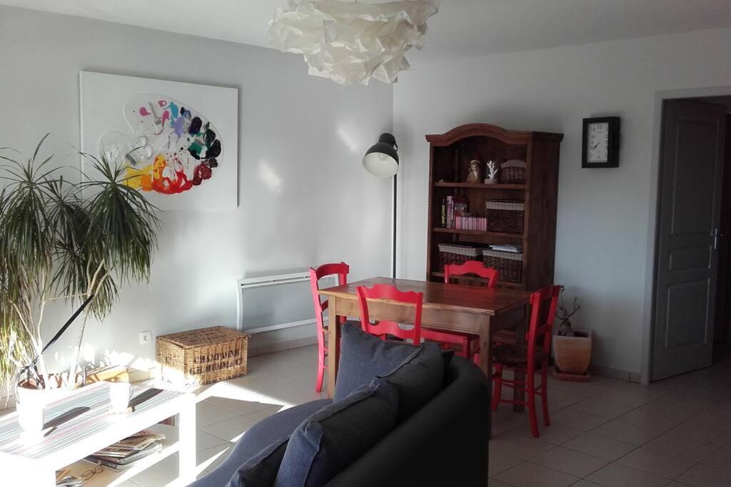 een woonkamer met een tafel en een bank bij Appart 2 pers, la montagne en ville, avec garage in Oloron-Sainte-Marie