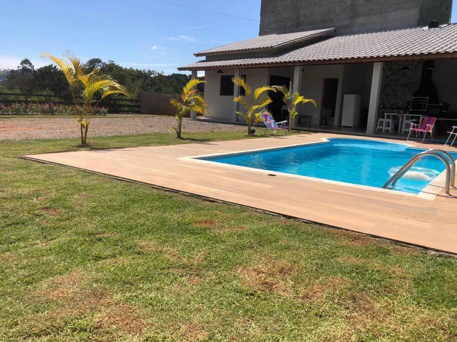 a swimming pool in a yard next to a house at Recanto do sol in Extrema