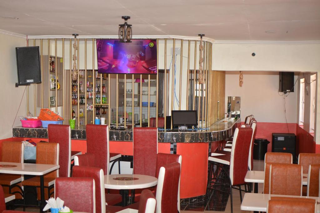 un restaurante con bar y TV en la pared en THE FARM BAR AND RESTAURANT, en Kakamega