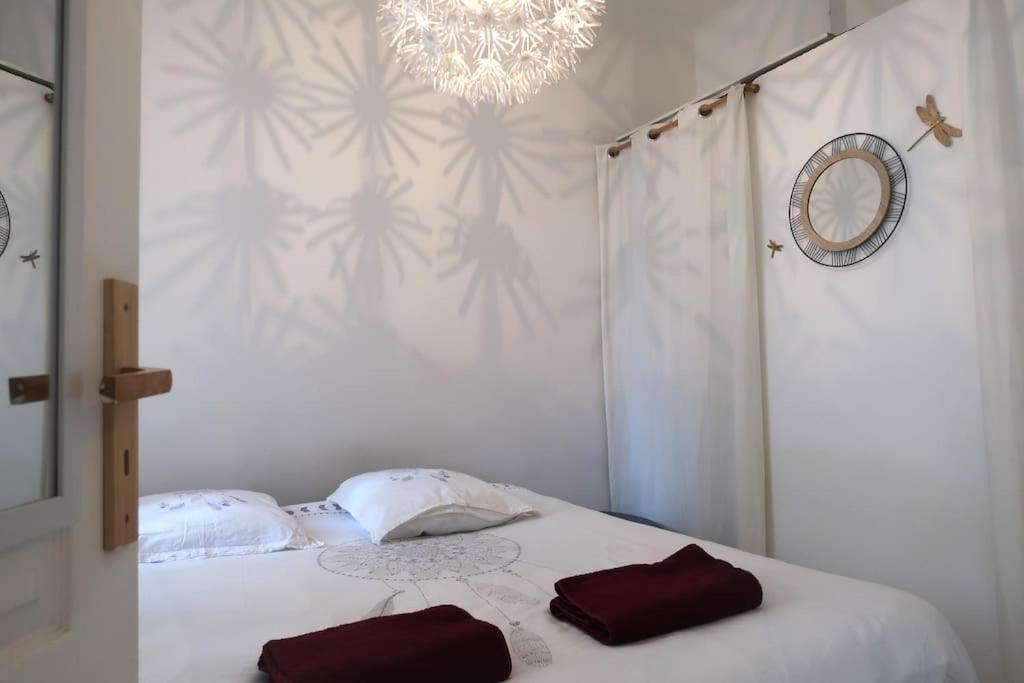 - une chambre avec un lit et 2 serviettes rouges dans l'établissement Cosy Catalan, à 50m de la plage, à Marseille