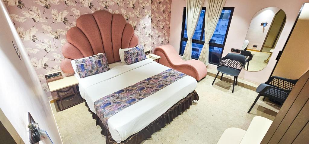 ein Hotelzimmer mit einem Bett und einem Stuhl in der Unterkunft Hotel Nova Bling in Rajkot
